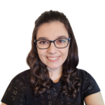 Headshot of smiling woman with black-framed glasses and brunette hair.