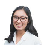 Headshot of smiling woman with black-framed glasses and brunette hair.