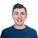 Headshot of a smiling man in blue shirt on a black background.